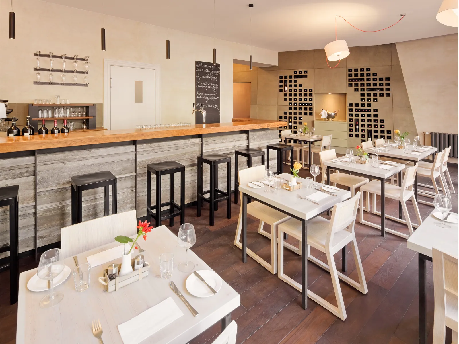 Gesamtansicht eines modern eingerichteten Restaurant-Gastraums mit Fokus auf Materialmix und Raumnutzung.