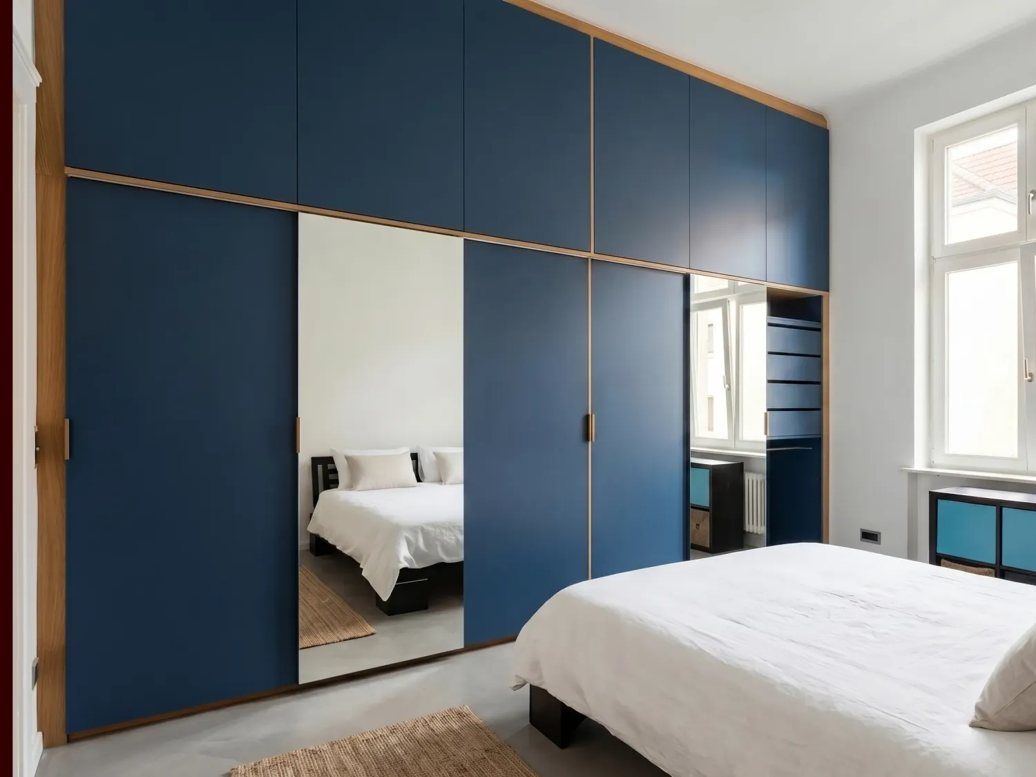 Einbauschrank mit blau lackierten Fronten, Eichengriffen und Spiegel-Schiebetüren in Berlin-Lichtenrade.